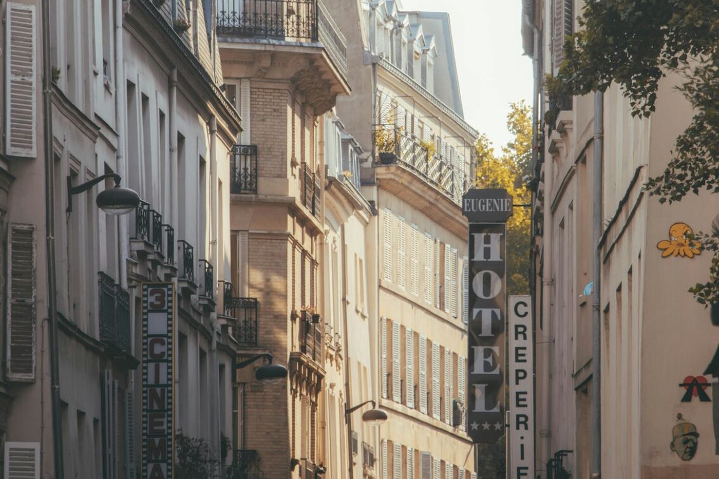 rue parisienne et enseigne verticale d'un hôtel indépendant